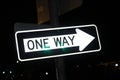 One Way street sign pointing to the right at night with nighttime reflection Royalty Free Stock Photo