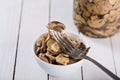 mushrooms in oil in ceramic bowl on white wooden background