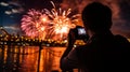 Silhouette of a young man taking a photo of a fireworks display