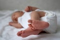 One week newborn adorable baby lying at baycot and funny yawning.Portrait of sleepy caucasian infant tired child on bed