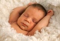 One week old baby on white blanket