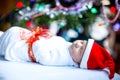 One week old newborn baby wrapped in blanket near Christmas tree Royalty Free Stock Photo