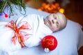 One week old newborn baby wrapped in blanket near Christmas tree Royalty Free Stock Photo