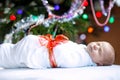 One week old newborn baby wrapped in blanket near Christmas tree Royalty Free Stock Photo