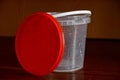 One wet white plastic bucket with a red lid Royalty Free Stock Photo