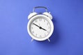 One white alarm clock on blue background, top view Royalty Free Stock Photo
