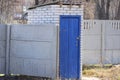 one white brick toilet with a closed wooden blue door Royalty Free Stock Photo