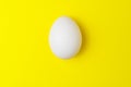 One white chicken egg on yellow background with empty space Royalty Free Stock Photo