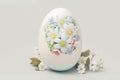 One white easter egg with beautiful floral pattern standing on light background. Generative AI Royalty Free Stock Photo