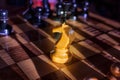 One white knight staying against full set of black chess pieces. Closeup of chessboard with wooden pieces on table in sunlight, Royalty Free Stock Photo