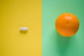 One white medical pill opposite orange on yellow and green background Royalty Free Stock Photo