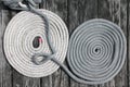 One white and one gray nylon boat rope on wooden deck Royalty Free Stock Photo