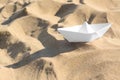 One white paper boat on sandy beach, space for text Royalty Free Stock Photo