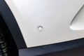 One white parking sensor on the bumper of a beautiful German black plastic car underneath for safety and collision Royalty Free Stock Photo