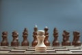 One white pawn closeup against a black army background in blur Royalty Free Stock Photo