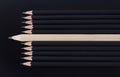 One white pencil standing out from the row of black pencils Royalty Free Stock Photo