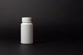 One white pill bottle on black background. box, bottle for pills Royalty Free Stock Photo