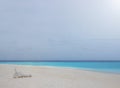 One white plastic beach chair on white sand beach with bright clear blue sky and colorful sea water. Royalty Free Stock Photo