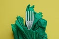 One white plastic fork wrapped in a green paper napkin Royalty Free Stock Photo