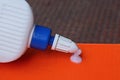 One white plastic tube with a drop of glue