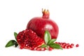 One whole and part of a pomegranate with pomegranate seeds and leaves Royalty Free Stock Photo