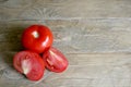 One whole and several cut tomatoes red, close-up  on brown wood backgroun Royalty Free Stock Photo