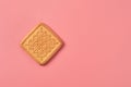One whole square cookie lies on pink desk on kitchen. Space for text Royalty Free Stock Photo