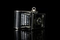 Vintage antique camera isolated on black glass Royalty Free Stock Photo