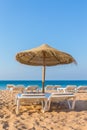 One wicker parasol with beach beds at sea Royalty Free Stock Photo