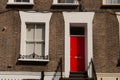 One window and one red door with different design in a brick wall. London Royalty Free Stock Photo