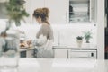 One woman alone in the kitchen in real life preparing food for lunch. Single lady lifestyle concept. White home interior minimal