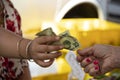 One woman hands another woman a twenty dollar bill against a blurred background Royalty Free Stock Photo