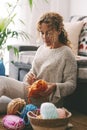 One woman having relax at home knitting working hobby sitting on the floor and enjoying handmade wool needles leisure activity