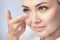 One woman holds contact lens on her finger. Eye care and the choice between the means to improve vision