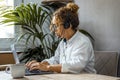 One woman at home in office workplace table using laptop and headset for voice and video call with clients for small business Royalty Free Stock Photo