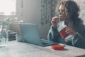 One woman at home using laptop and eating cookies from the box. Concept of bad nutrition food habits lifestyle female people and Royalty Free Stock Photo