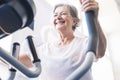 One woman mature or senior at the gym training and doing exercise in on a machine - active pensioner lifestyle and concept Royalty Free Stock Photo