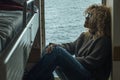 One woman passenger inside cabin boat cruise ferry having relax sitting near the window with ocean sea in background outside. Royalty Free Stock Photo