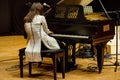 One woman plays piano in a concert