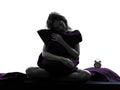 Woman sleepy hugging pillow sitting on bed silhouette Royalty Free Stock Photo
