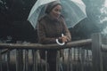 One woman under the rain protected by a transparent umbrella enjoy bad romantic rainy weather condition in autumn winter outdoor