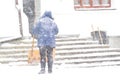 One women shovelling snow in the snowstrom. Cleaning stairs