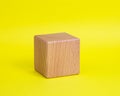 One wooden cube square on yellow background copyspace
