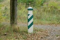 One wooden striped pillar stands in the grass Royalty Free Stock Photo