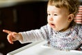 The one-year child points his finger, demanding more food