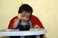 One 1 year old Asian baby boy learning to eat by himself, messy on baby dining chair at home Royalty Free Stock Photo