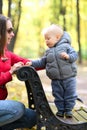 One year old baby boy in autumn park with his mother Royalty Free Stock Photo