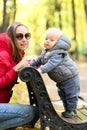 One year old baby boy in autumn park with his mother Royalty Free Stock Photo