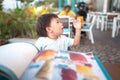 One year old baby boy calling the waiter to order and choose his meal in the restaurant Royalty Free Stock Photo