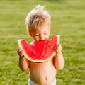 One year old baby boy eating watermelon in the garden Royalty Free Stock Photo